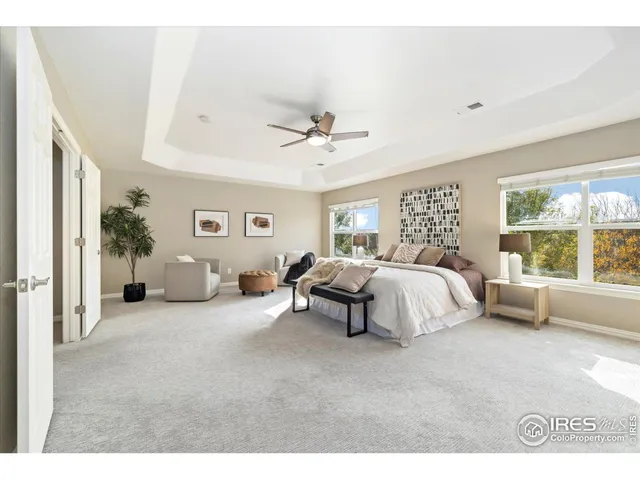 a bedroom with a bed couch and a large window
