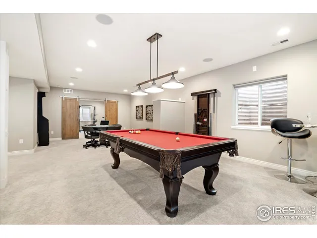 a room with pool table and windows