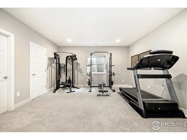 a room with gym equipment and large mirror