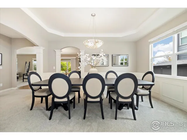 a dining room with furniture a chandelier and a window