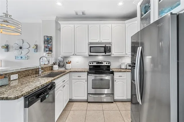 a kitchen with stainless steel appliances granite countertop a stove a sink and a microwave