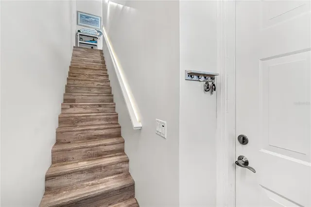 a living room with stainless steel appliances furniture a rug and a view of kitchen