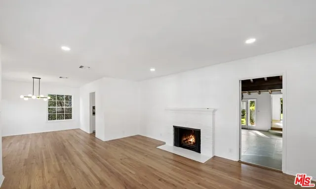 a view of a livingroom with wooden floor and a fireplace