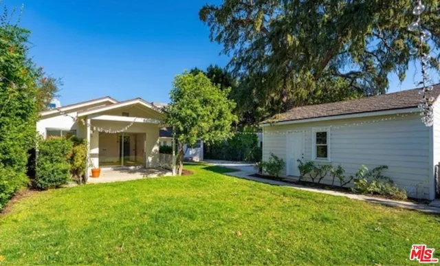 a view of a chair and table in backyard of the house