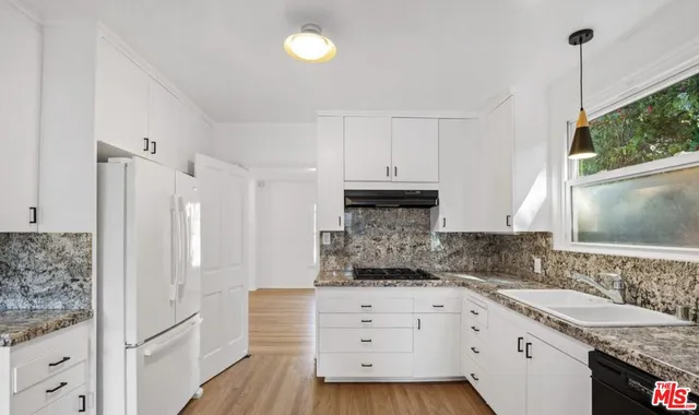 a kitchen with granite countertop white cabinets and white appliances
