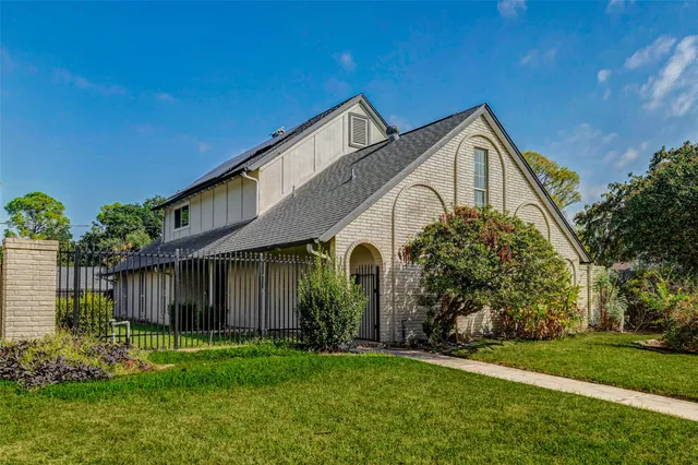 a front view of a house with a garden and plants