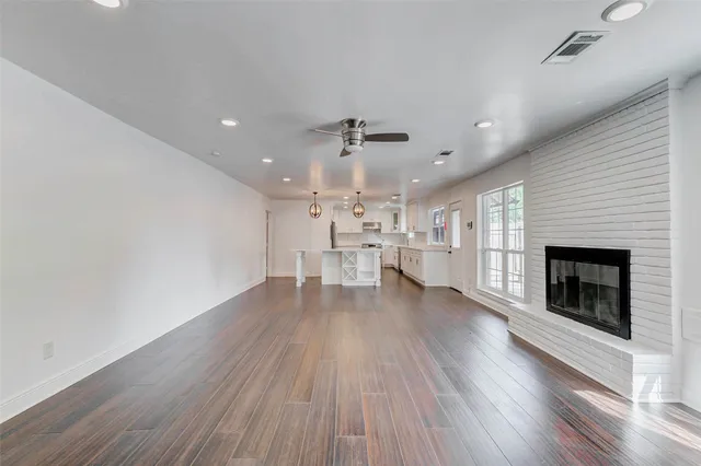 a view of an empty room with a fireplace and a window