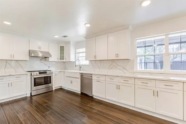 a kitchen with granite countertop white cabinets and white appliances