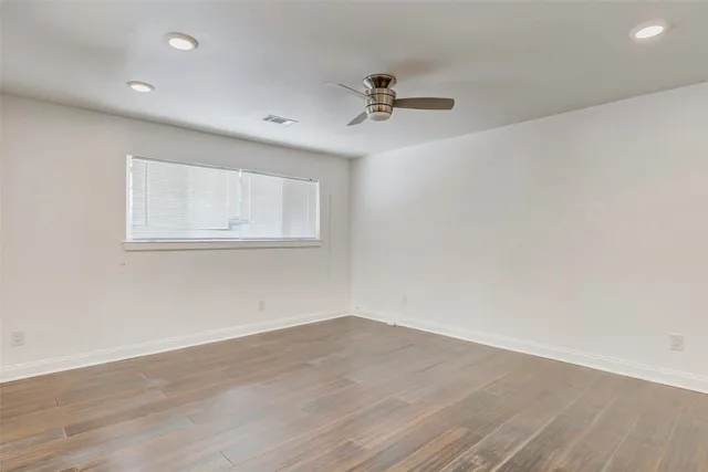 a view of a room with wooden floor and fan