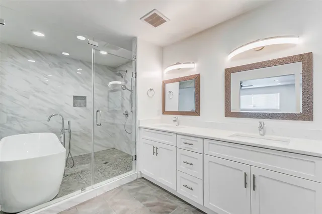 a bathroom with a double vanity sink mirror and shower