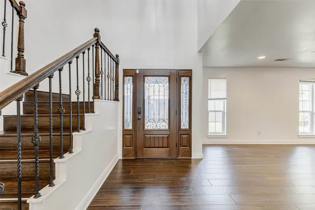 a view of an entryway with wooden floor and door