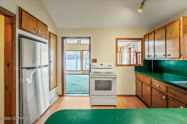 a kitchen with granite countertop a refrigerator and a stove top oven