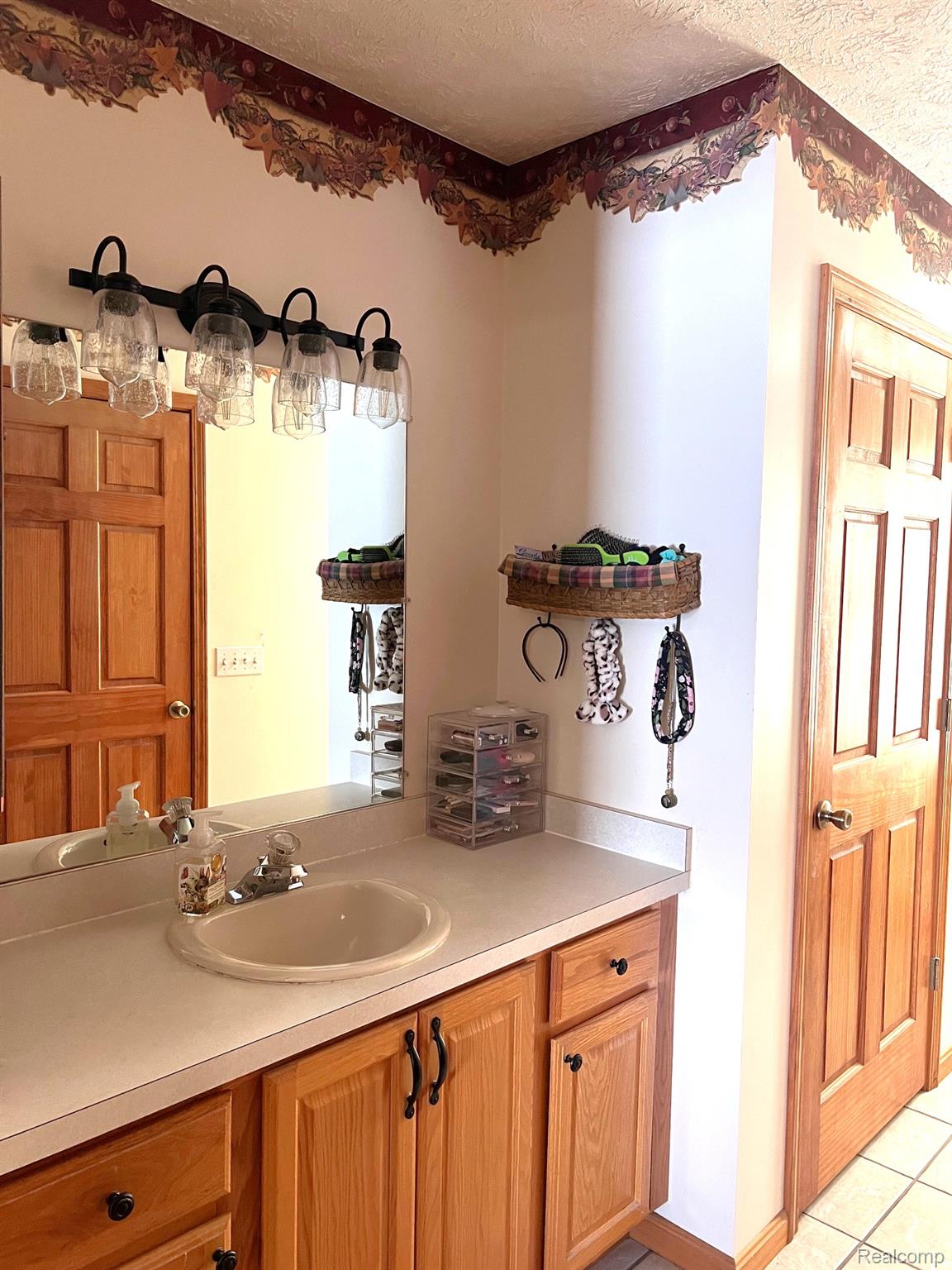 651 East Beard Road Perry, MI 48872 - Photo 10 of 29 Bathroom with vanity, a textured ceiling, and light tile patterned floors