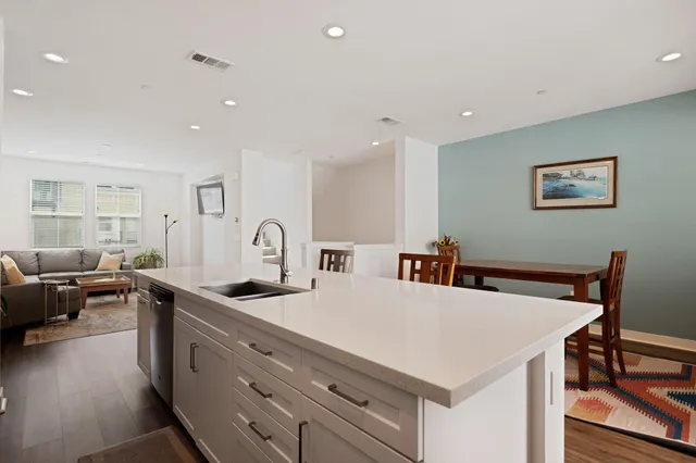 a large white kitchen with sink and furniture