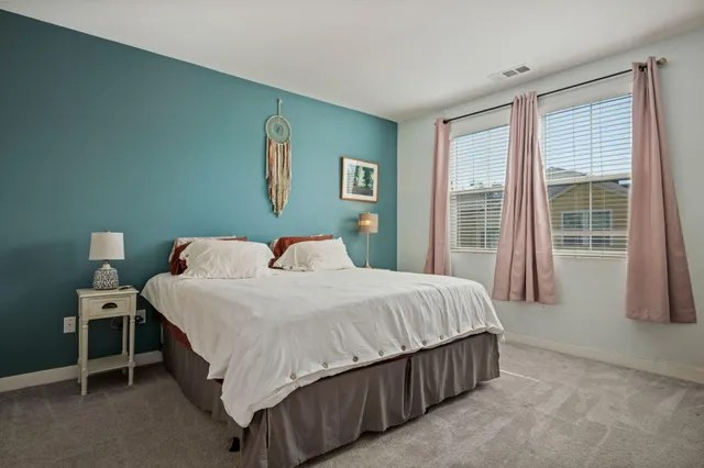 a bedroom with a bed lamp and a large window