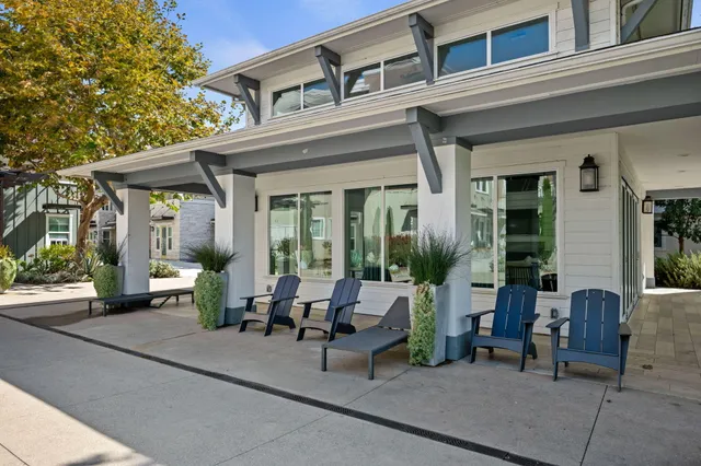 a view of a patio with couches table and chairs and potted plants