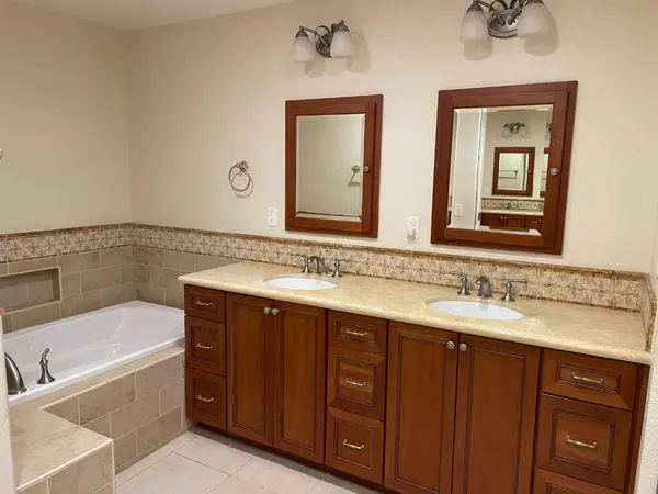 a bathroom with a tub sink and mirror