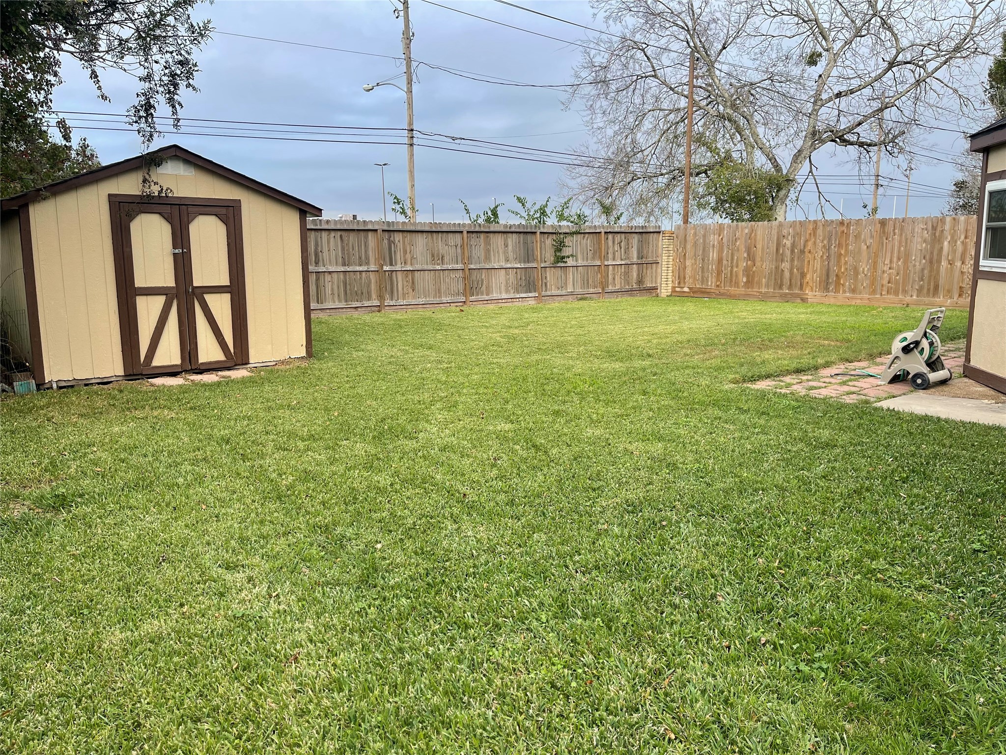 1225 Clover Drive Angleton, TX 77515 - Photo 13 of 15 a view of a backyard with a small cabin and a chair