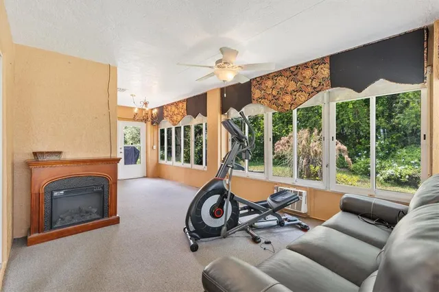 a view of a livingroom with furniture wooden floor windows and a fireplace