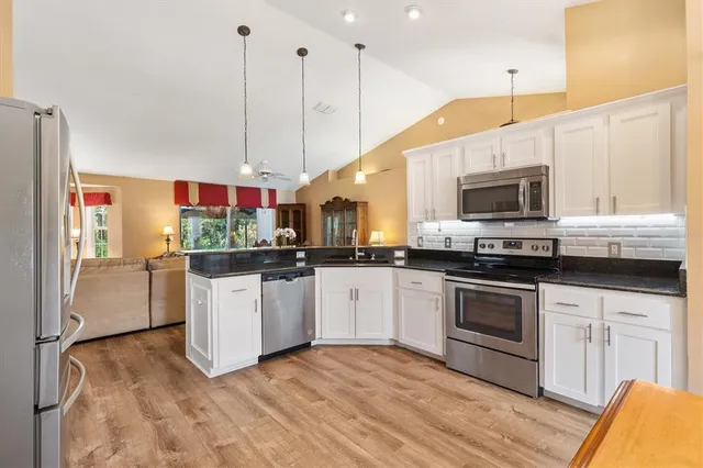 a kitchen with stainless steel appliances granite countertop a stove a sink and a microwave