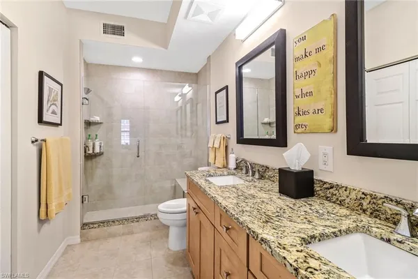 a bathroom with a granite countertop sink toilet and shower