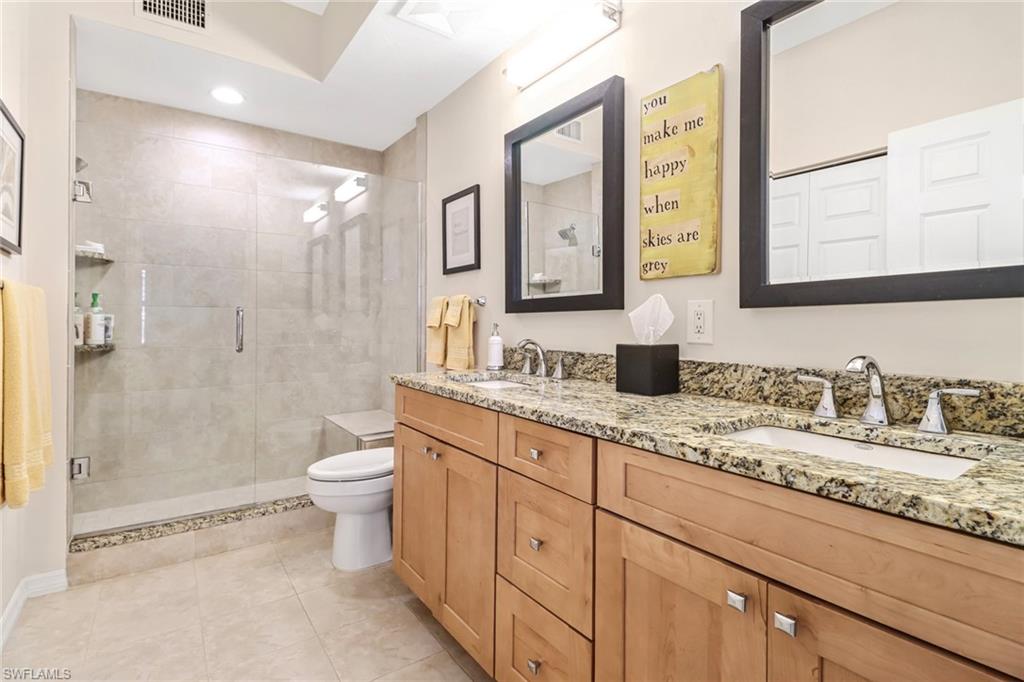 401 Bayfront Place, Unit 3205 Naples, FL 34102 - Photo 18 of 35 a bathroom with a granite countertop sink a toilet a mirror and shower
