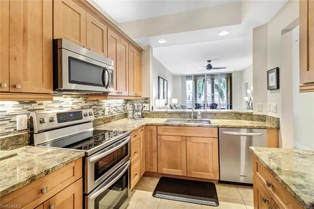 a kitchen with stainless steel appliances granite countertop a stove microwave and cabinets