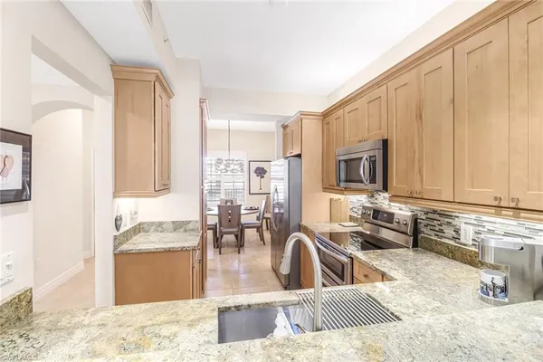 a view of a kitchen with kitchen island granite countertop a sink and a stove top oven