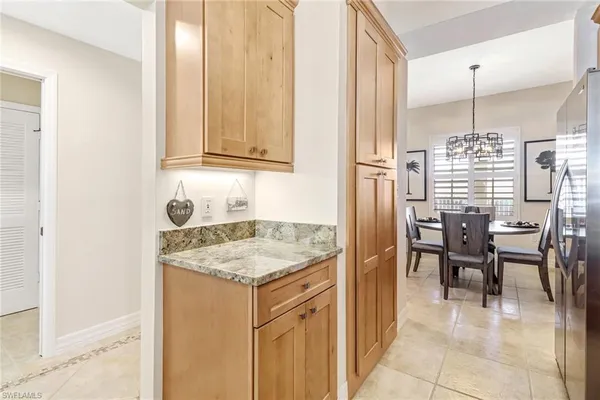 a kitchen with kitchen island granite countertop wooden cabinets a refrigerator and a sink
