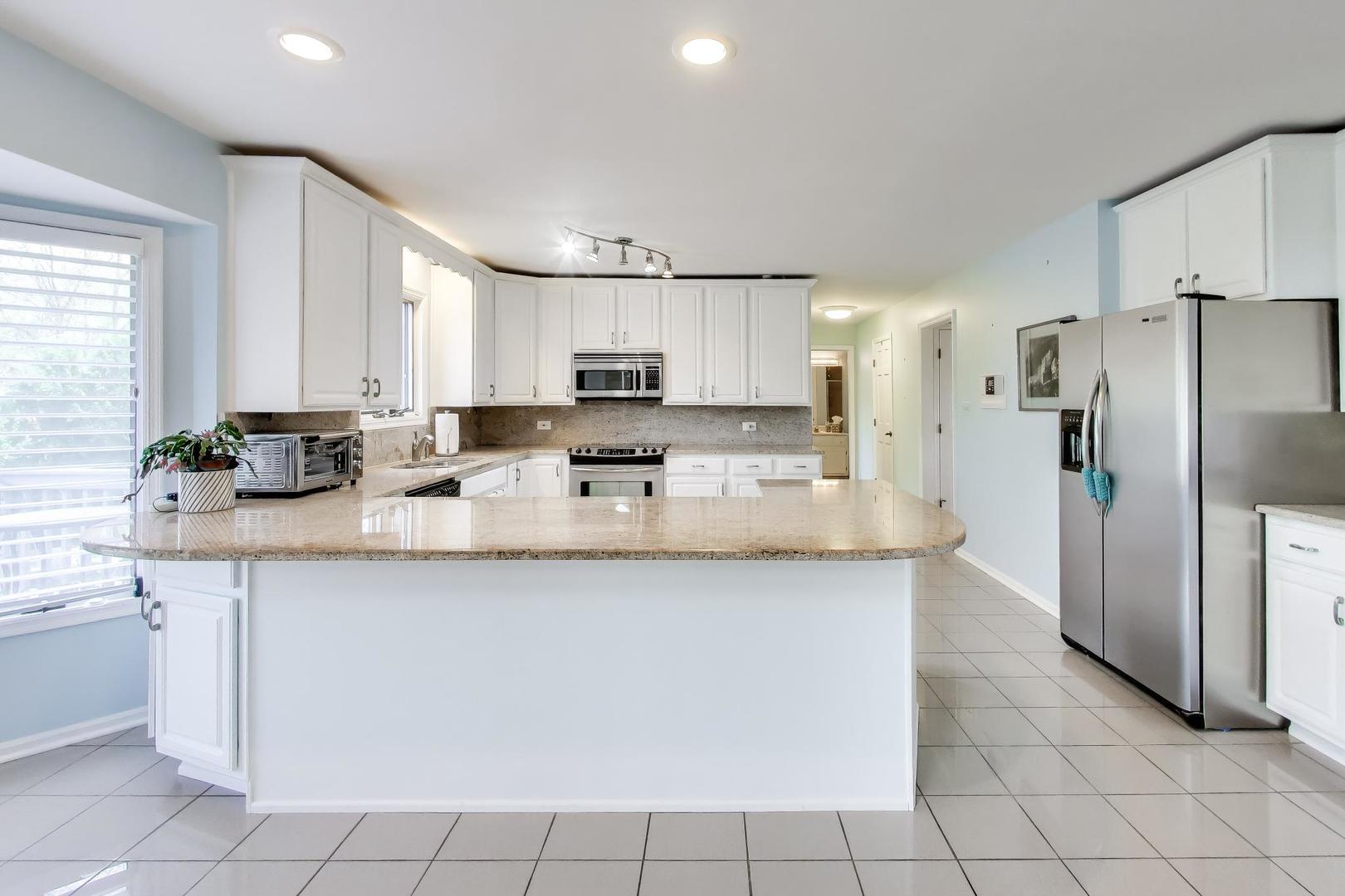 766 Camelot Drive Burr Ridge, IL 60527 - Photo 12 of 48 a kitchen with stainless steel appliances a sink a stove a refrigerator and cabinets
