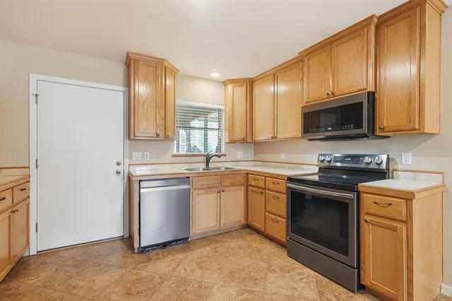 a kitchen with stainless steel appliances granite countertop a stove a sink and a microwave