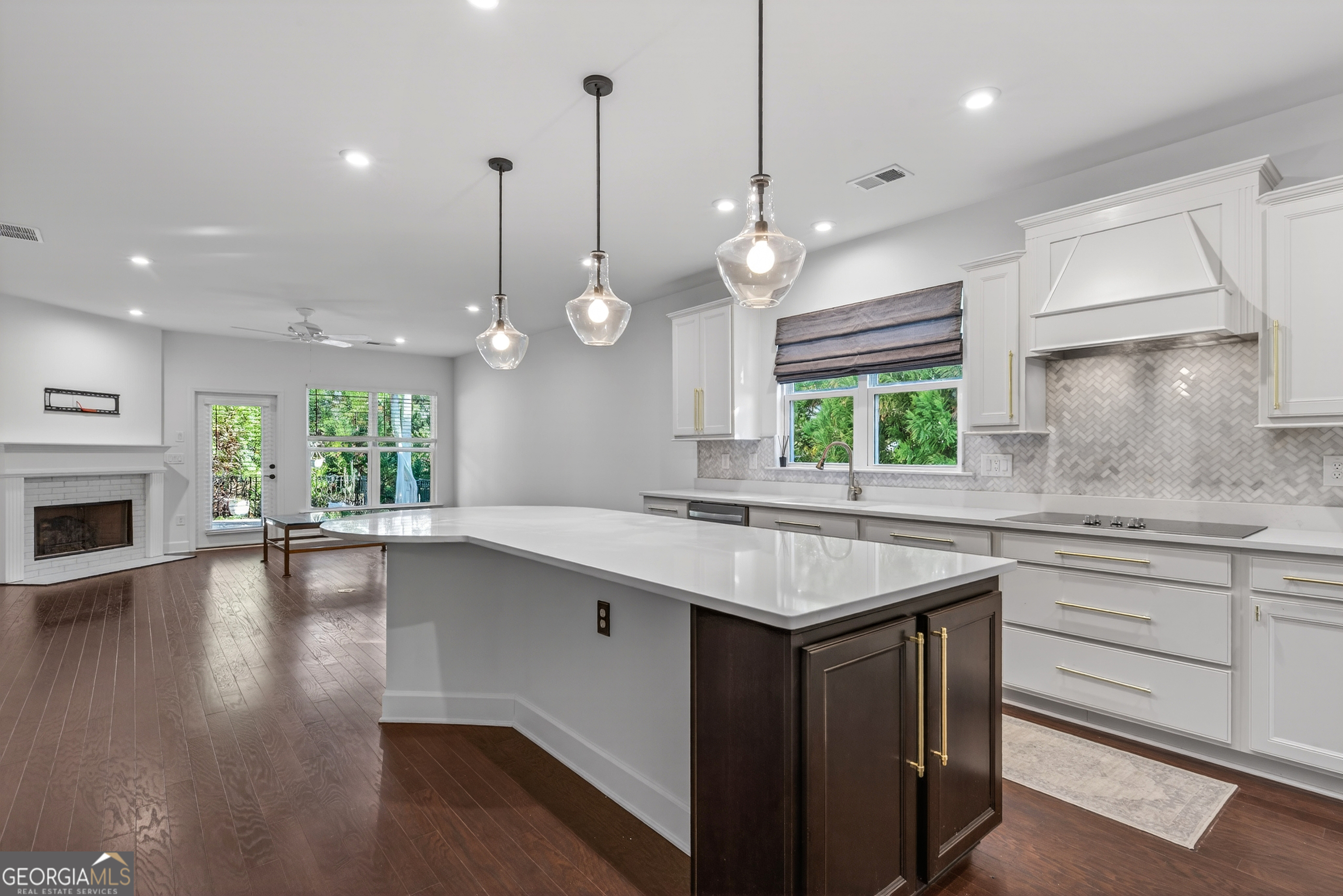 1060 Lone Oak Road Greensboro, GA 30642 - Photo 6 of 26 a kitchen with kitchen island granite countertop a stove a sink a center island and a wooden floor