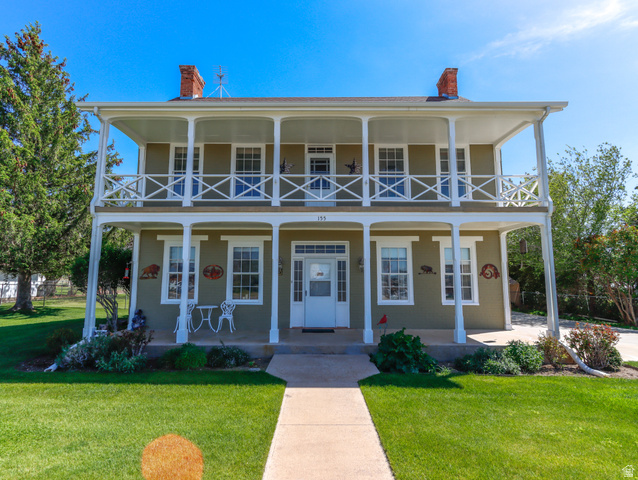 155 West Center Street Fillmore, UT 84631 - Photo 3 of 86 Two-story colonial-style facade featuring double-tier covered porches, white railings, and twin brick chimneys