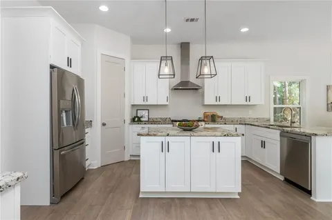 a kitchen with granite countertop a stove and white cabinets