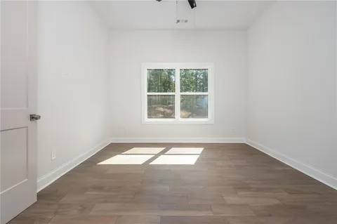 a bathroom with a granite countertop toilet a sink a mirror a bathtub and shower