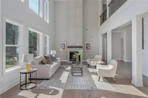 a living room with fireplace furniture and a large window