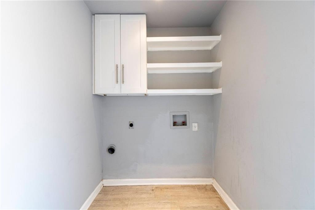2105 Fortview Road Austin, TX 78704 - Photo 19 of 37 Functional laundry space equipped with overhead storage and shelving.