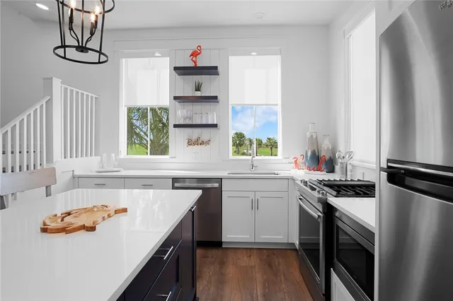 a kitchen with stainless steel appliances a sink a stove and a window