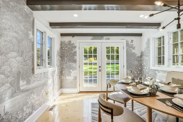 a dining room with furniture and a large window
