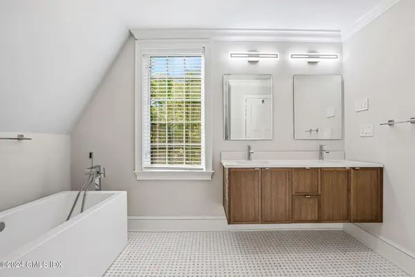 a bathroom with a bathtub shower sink and a mirror