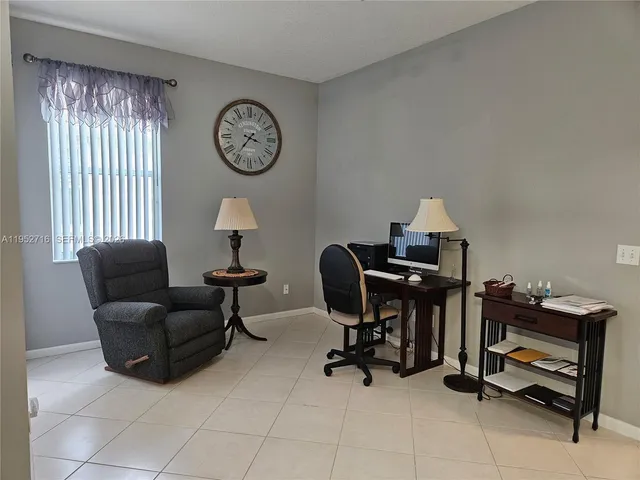 a view of a workspace with furniture and a window
