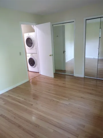 an empty room with wooden floor and white walls
