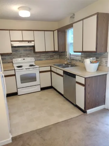 a kitchen with granite countertop a sink and white cabinets