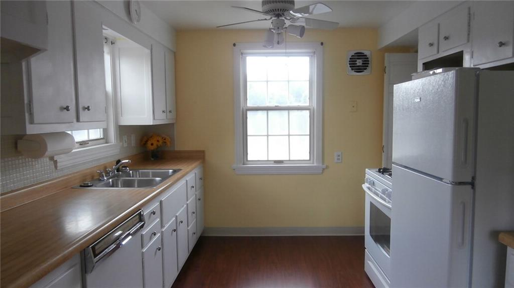 1030 Hastie Road Pittsburgh, PA 15234 - Photo 5 of 19 Cozy and bright fully equipped kitchen with refinished cabinets and hardware, bifold door heading downstairs, brand new refrigerator, dishwasher, gas stove, microwave and ceiling fan.