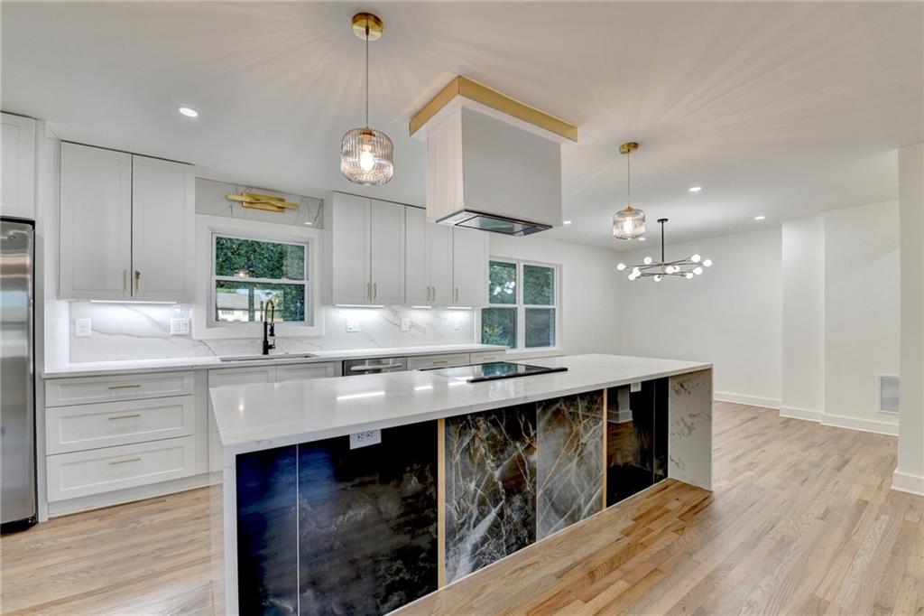 2181 Juanita Street Decatur, GA 30032 - Photo 5 of 15 a kitchen with stainless steel appliances granite countertop a sink a stove and a wooden floors