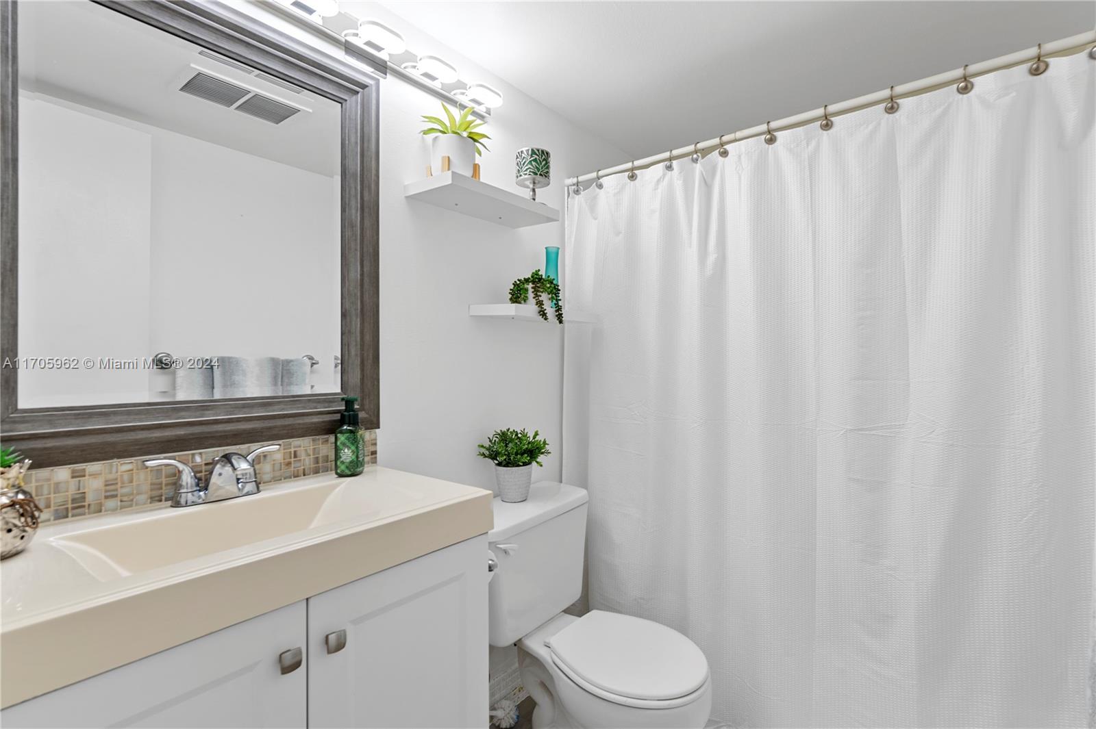 382 Markham R, Unit 382 Deerfield Beach, FL 33442 - Photo 9 of 30 a bathroom with a sink a toilet and a mirror