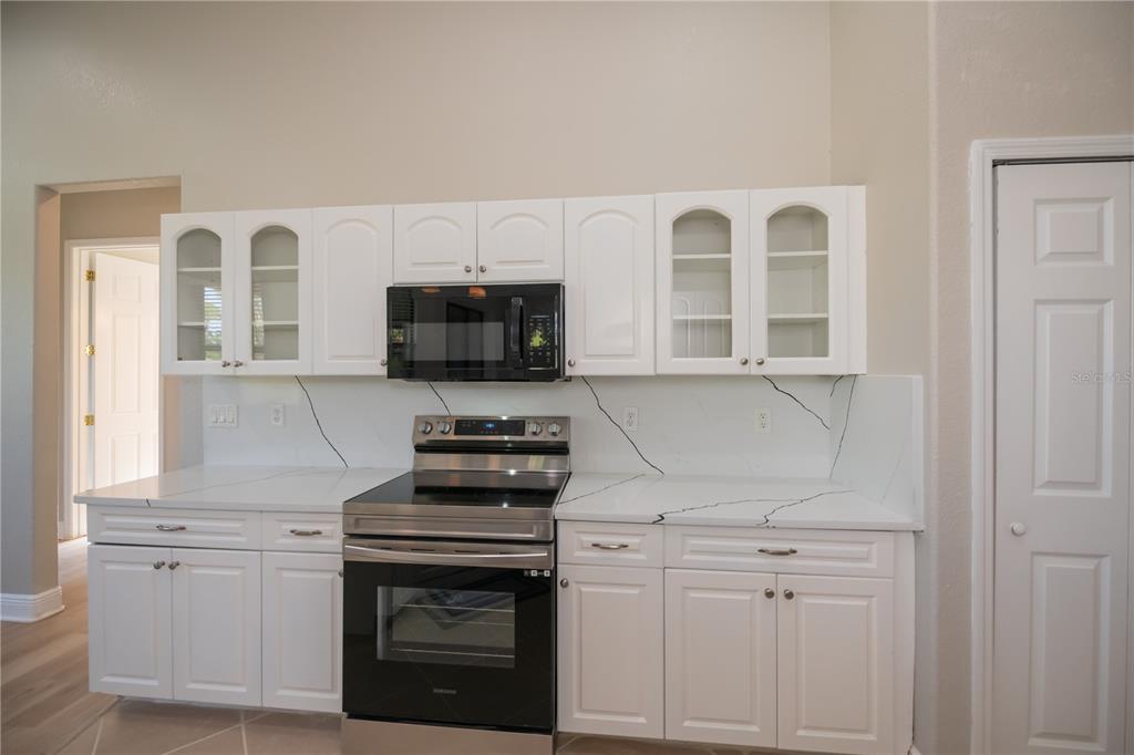 3284 Newmark Street North Port, FL 34291 - Photo 15 of 44 a kitchen with white cabinets stainless steel appliances and sink