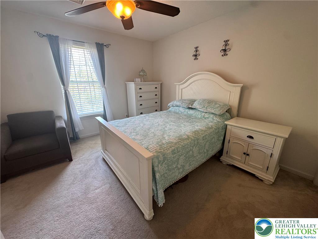2742 Long Pond Road Long Pond, PA 18334 - Photo 32 of 57 A well-lit bedroom features plush carpeting and a classic white bed frame, creating a comfortable personal retreat.