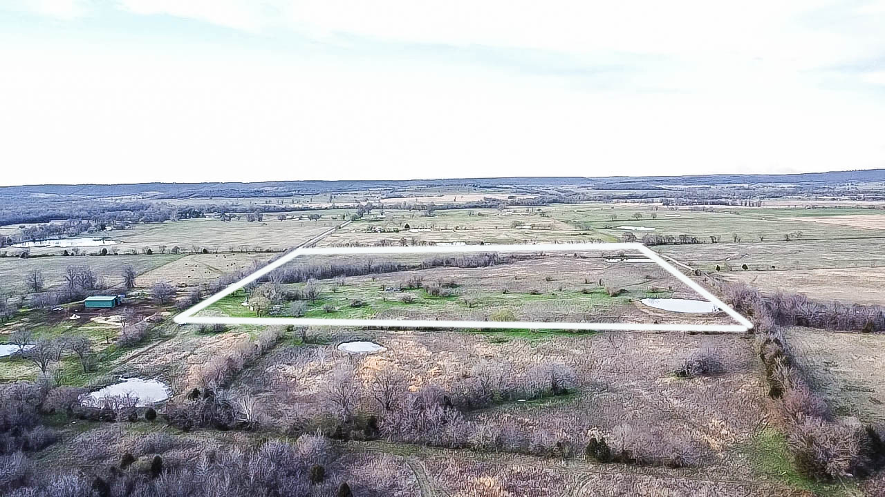 Expansive undeveloped land featuring multiple ponds and a small outbuilding