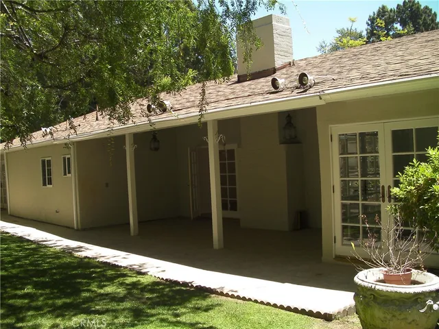 a backyard of a house with fountain table and chairs
